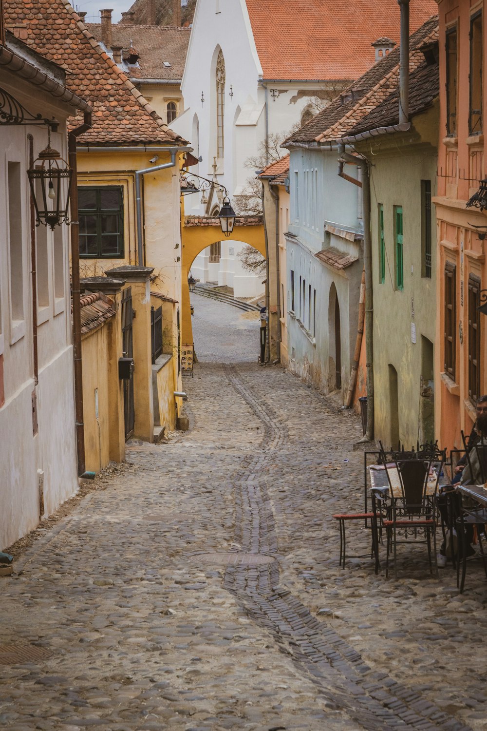 a cobblestone street lined with tables and chairs