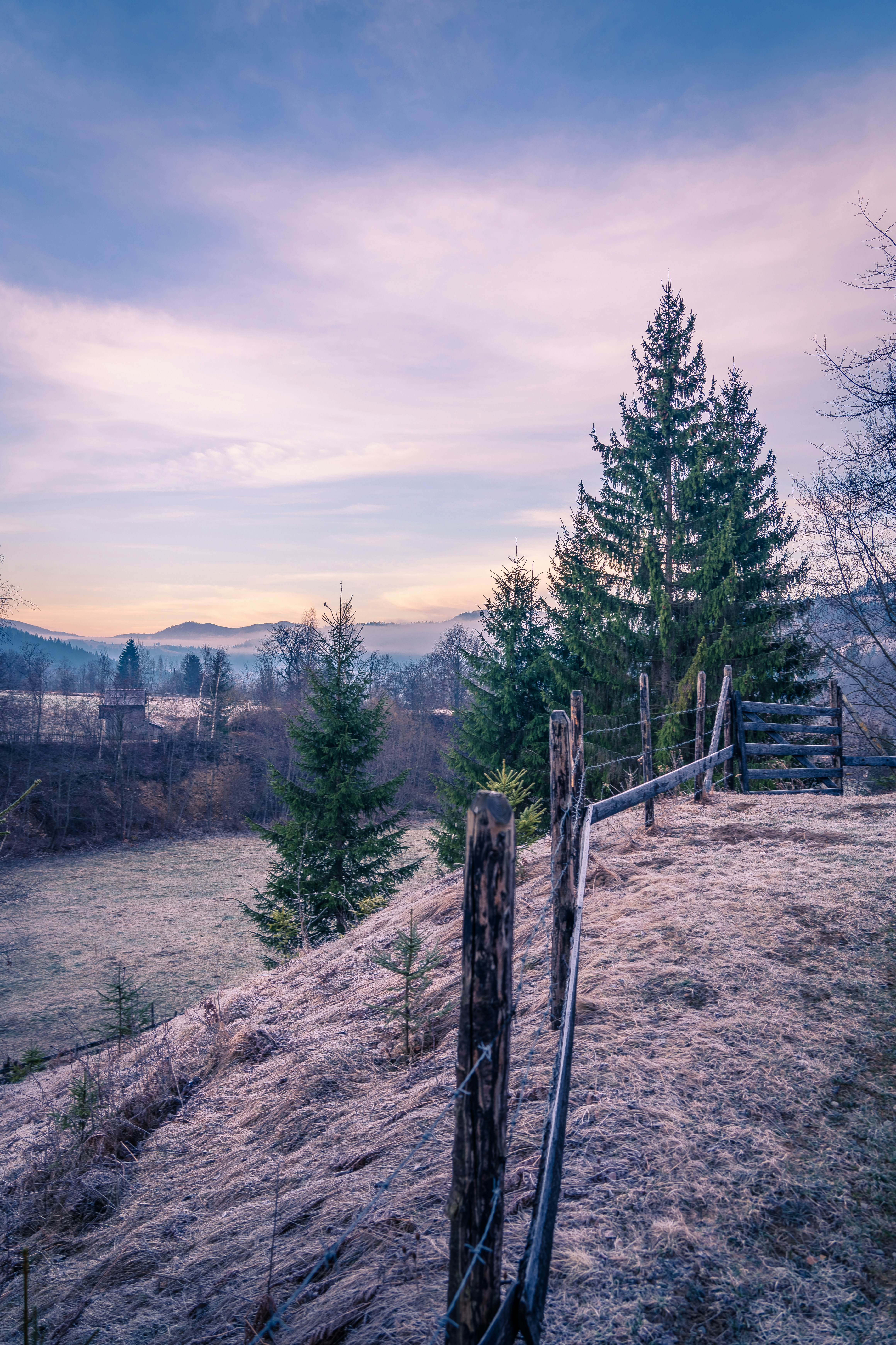 a wooden fence sitting on top of a grass covered hillside