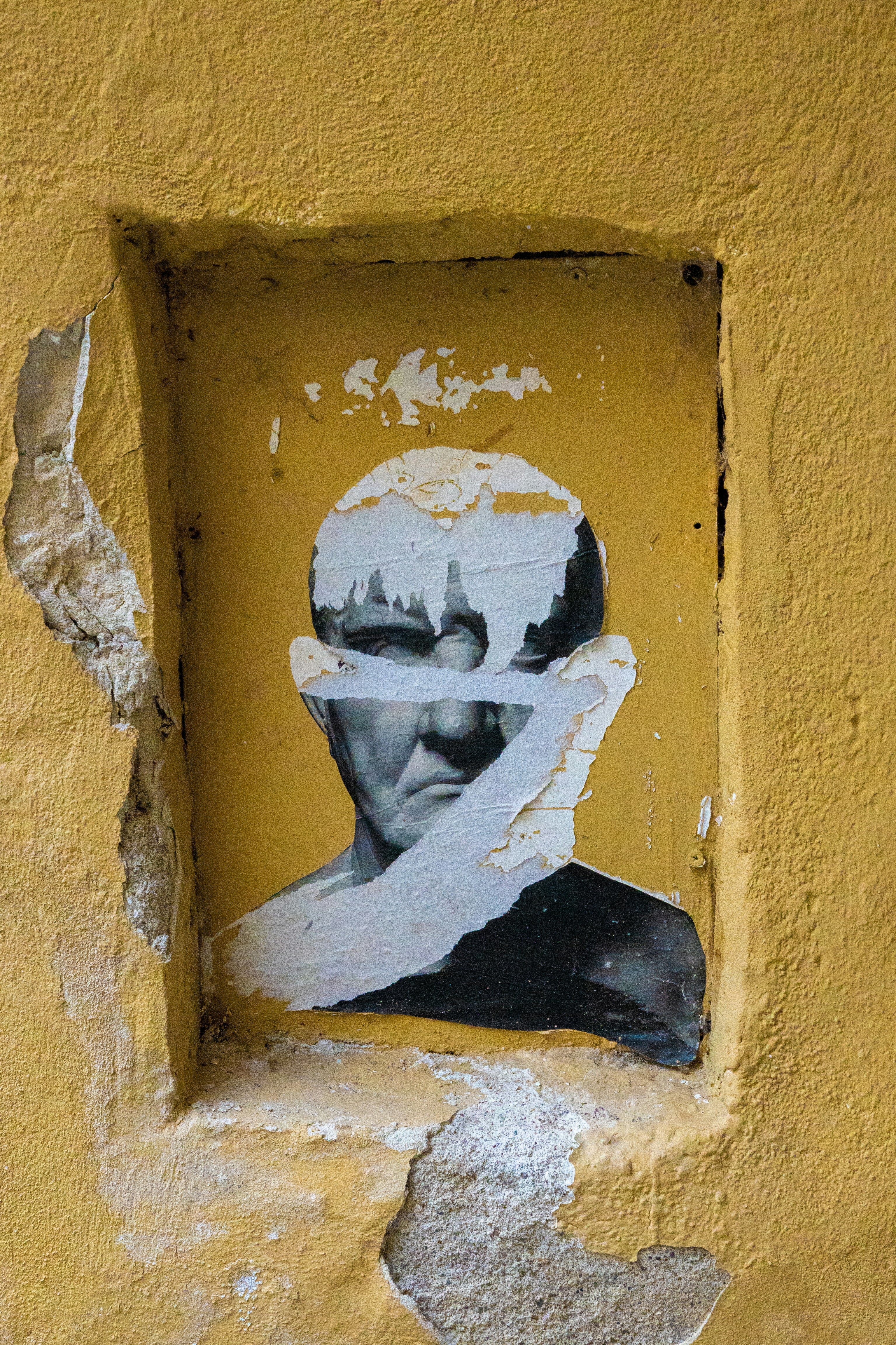 Ein Bild eines Mannes ist auf eine gelbe Wand gemalt