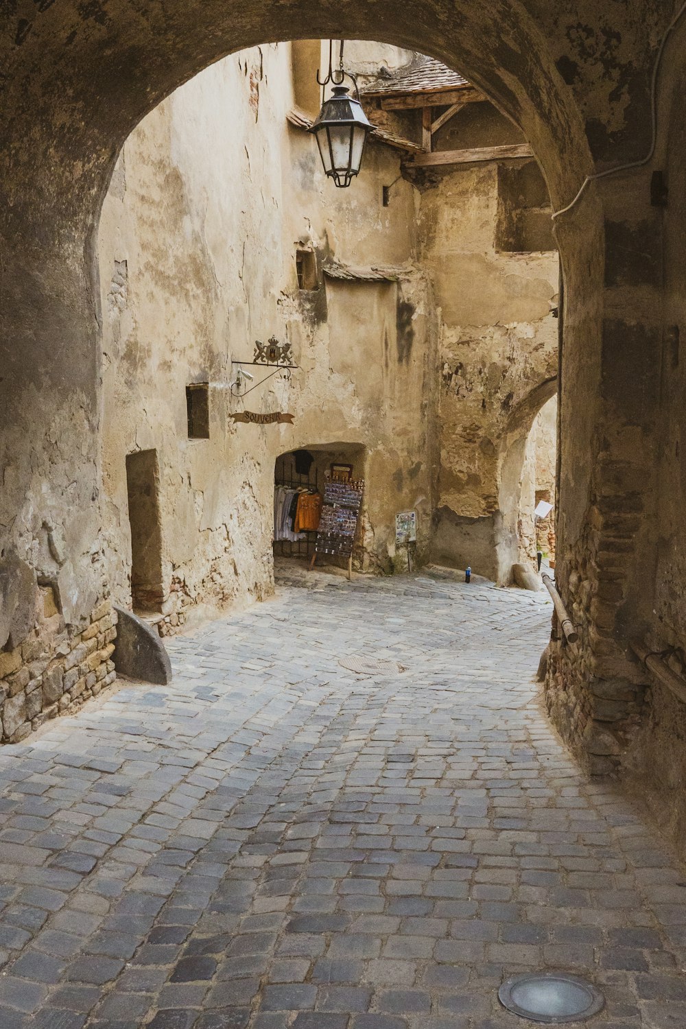 a cobblestone street with a lantern hanging from the ceiling