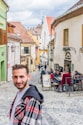 a man standing in the middle of a cobblestone street