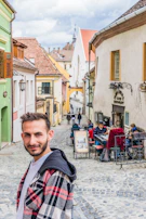 a man standing in the middle of a cobblestone street