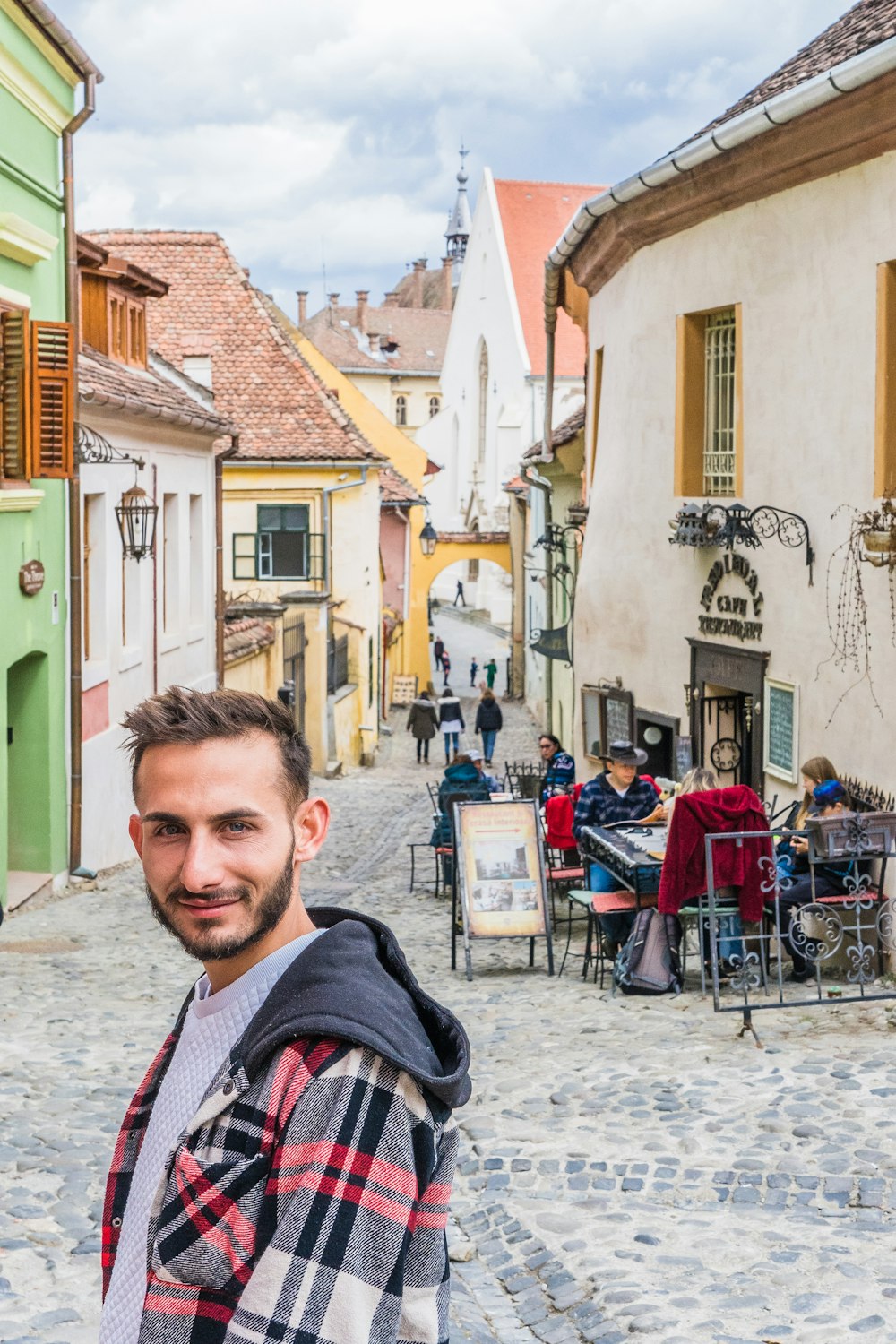 a man standing in the middle of a cobblestone street