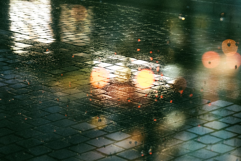 a reflection of a person holding an umbrella in the rain