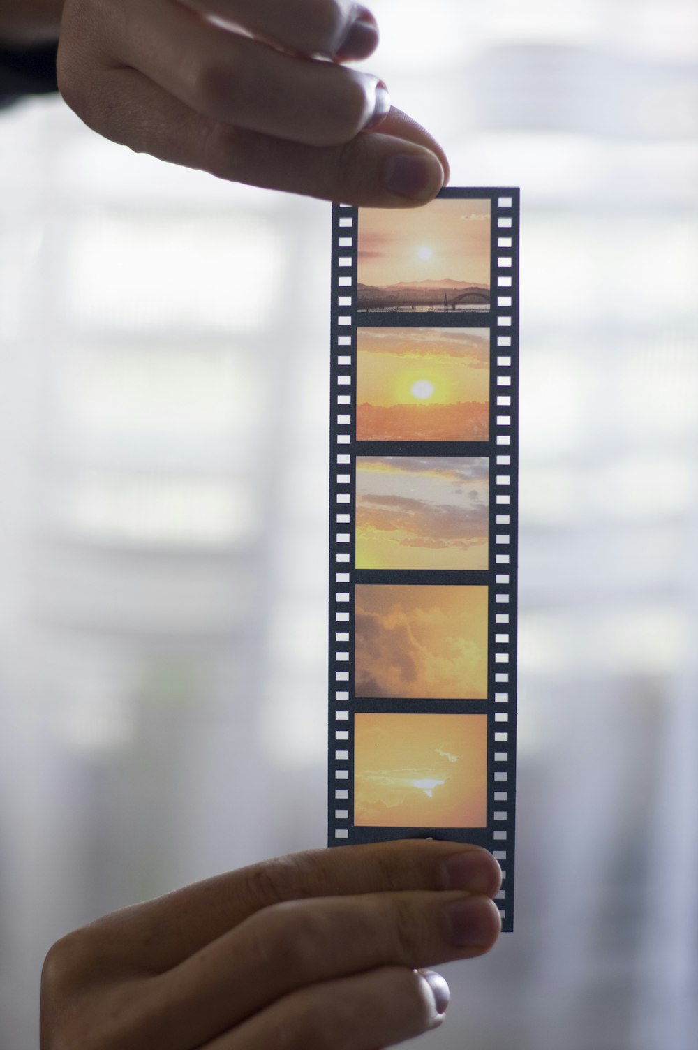 a person holding up a film strip with pictures on it
