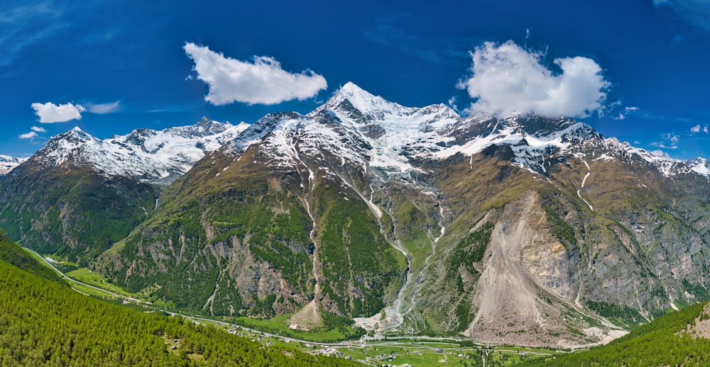 a scenic view of a mountain range with a valley in the foreground