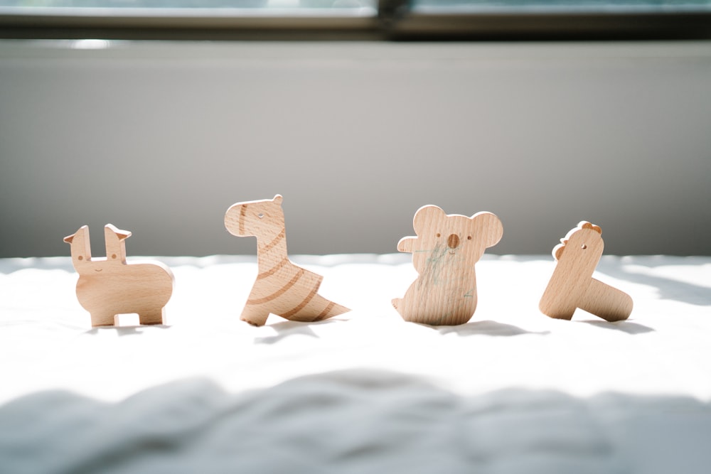 a group of wooden animals sitting on top of a bed