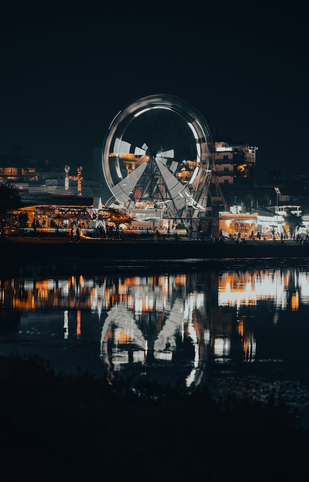 a large ferris wheel sitting next to a body of water