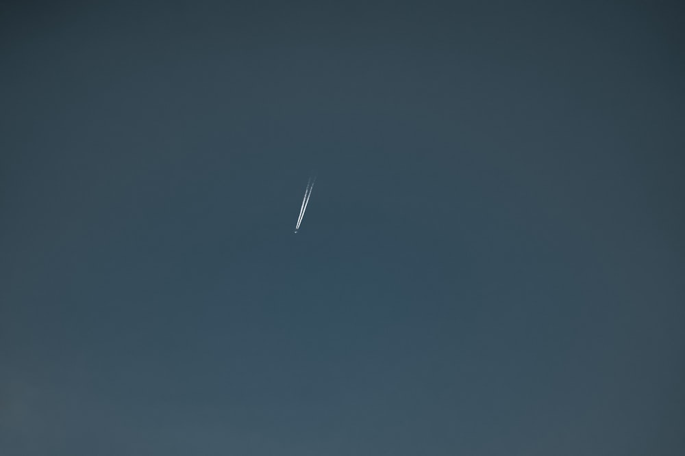 a jet flying through a dark blue sky