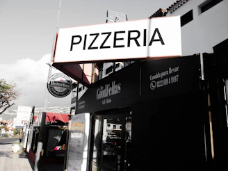 a sign that says pizzeria on the side of a building