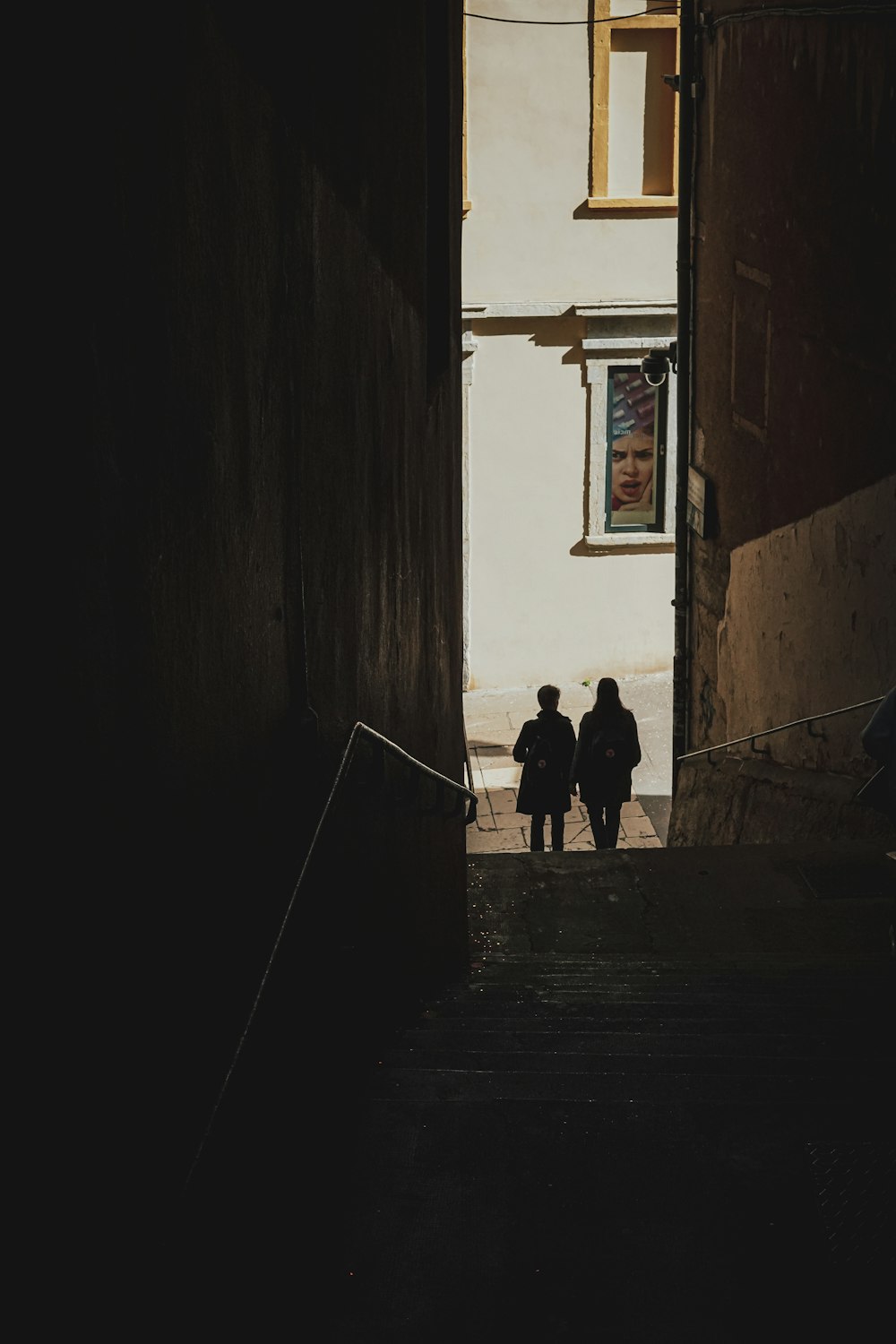 two people walking down a dark alley way