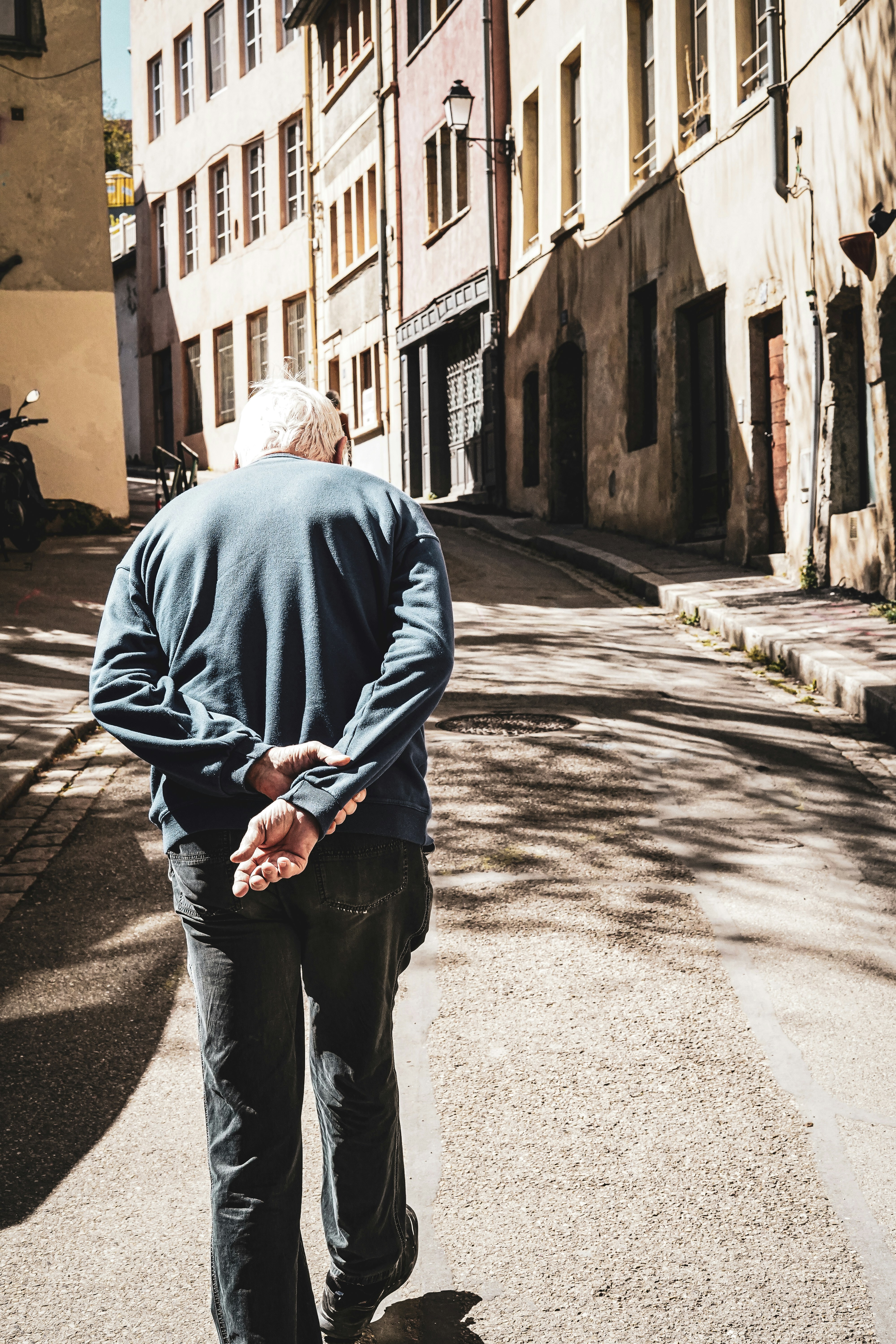 Old man walking up a hill in Lyon, France
