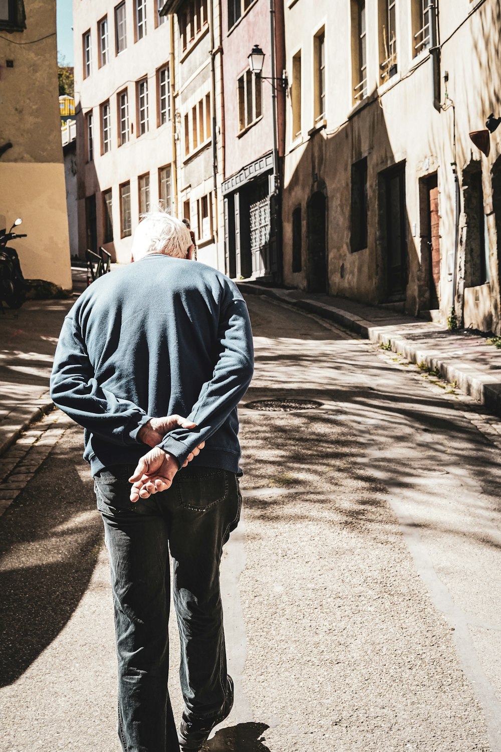 um homem andando de skate por uma rua ao lado de edifícios altos