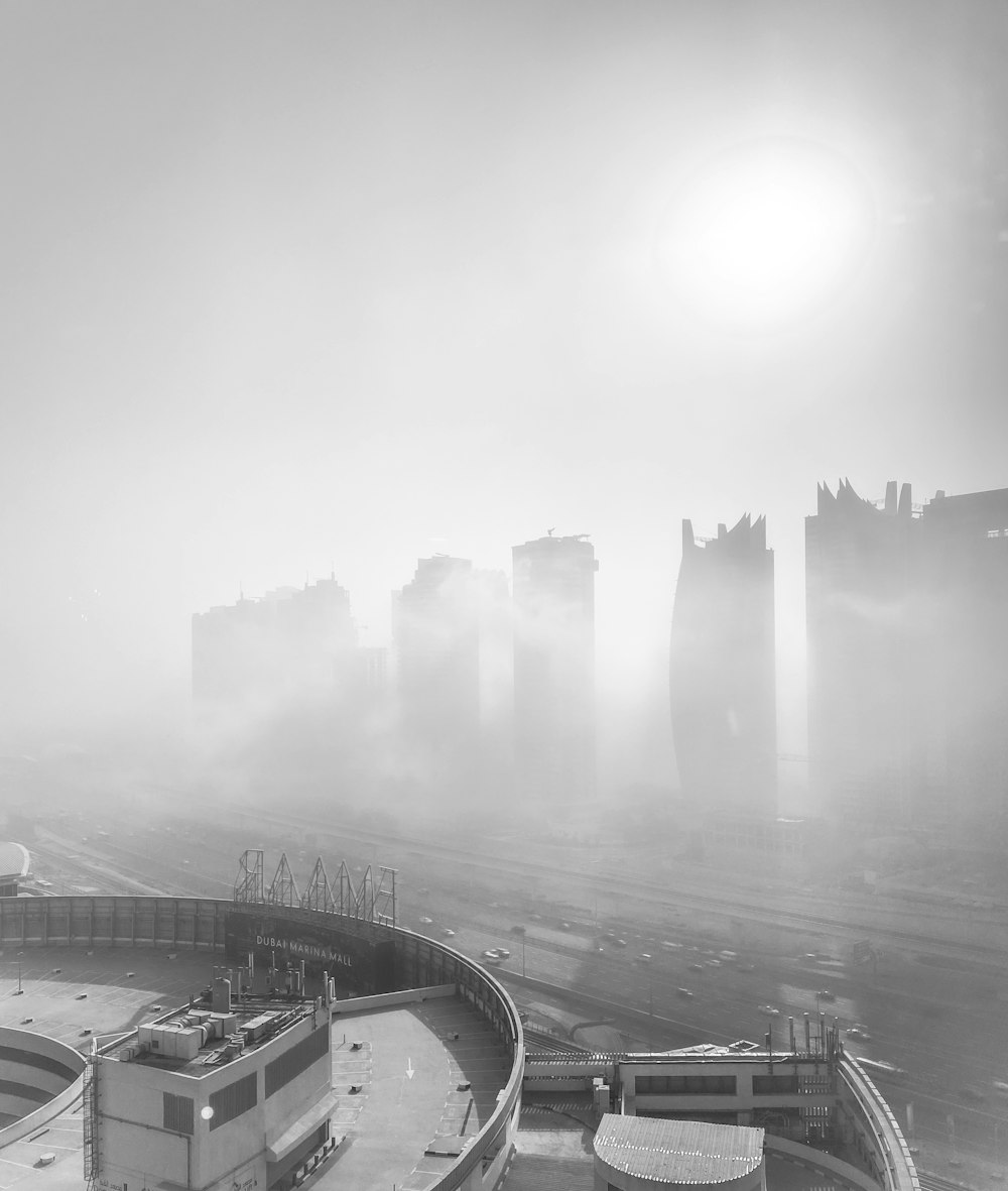 a black and white photo of a foggy city