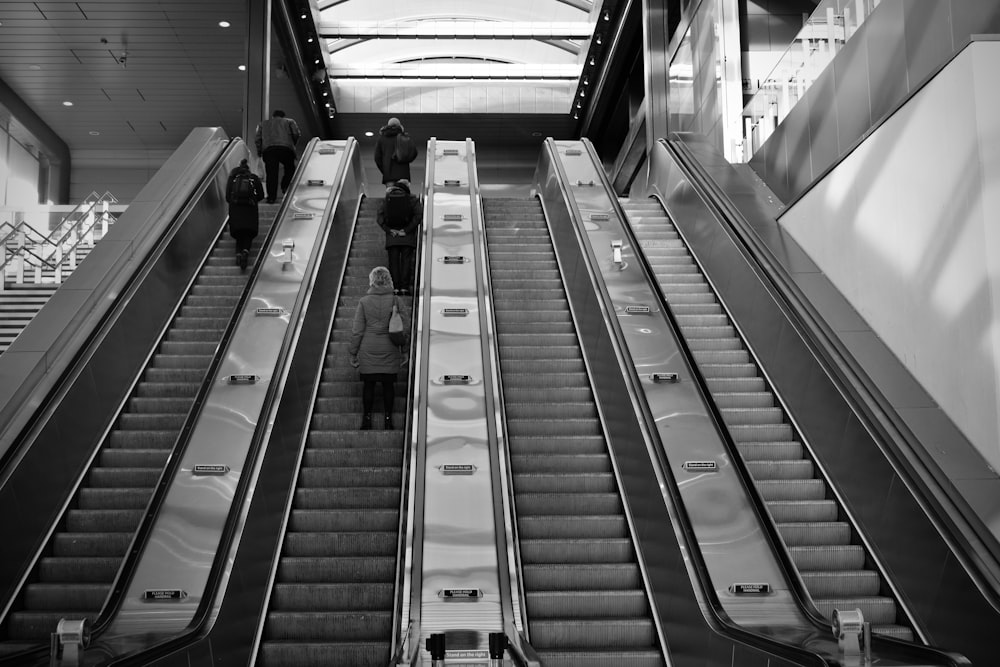 a couple of people riding down an escalator