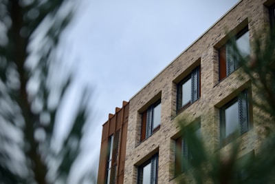 Exterior view of a brown brick commercial building surrounded by trees