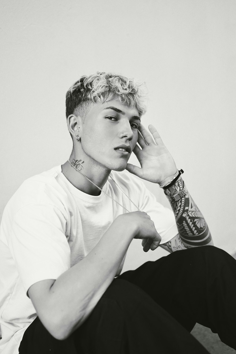 a black and white photo of a man with tattoos