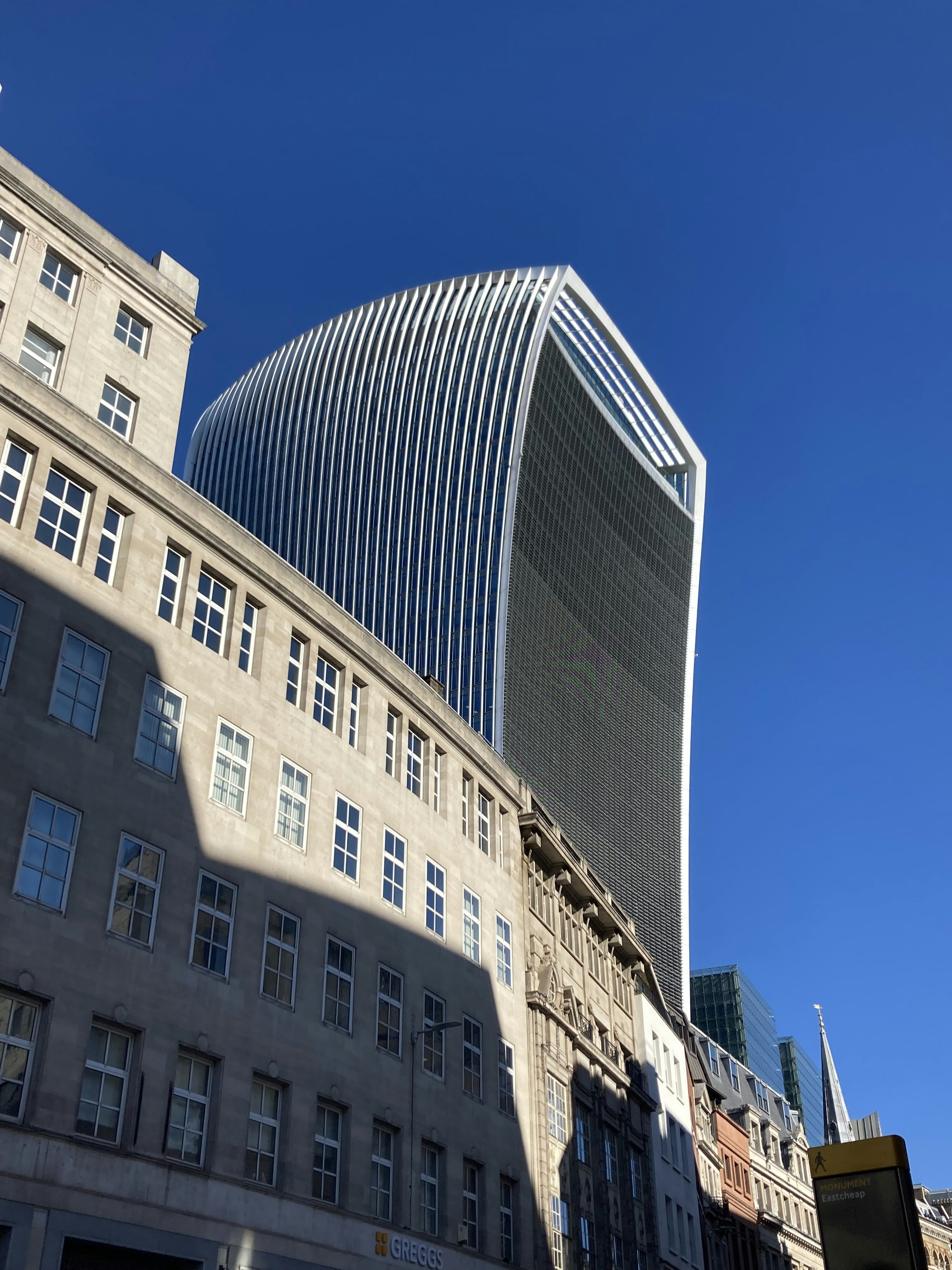 A tall building with a curved roof next to other buildings