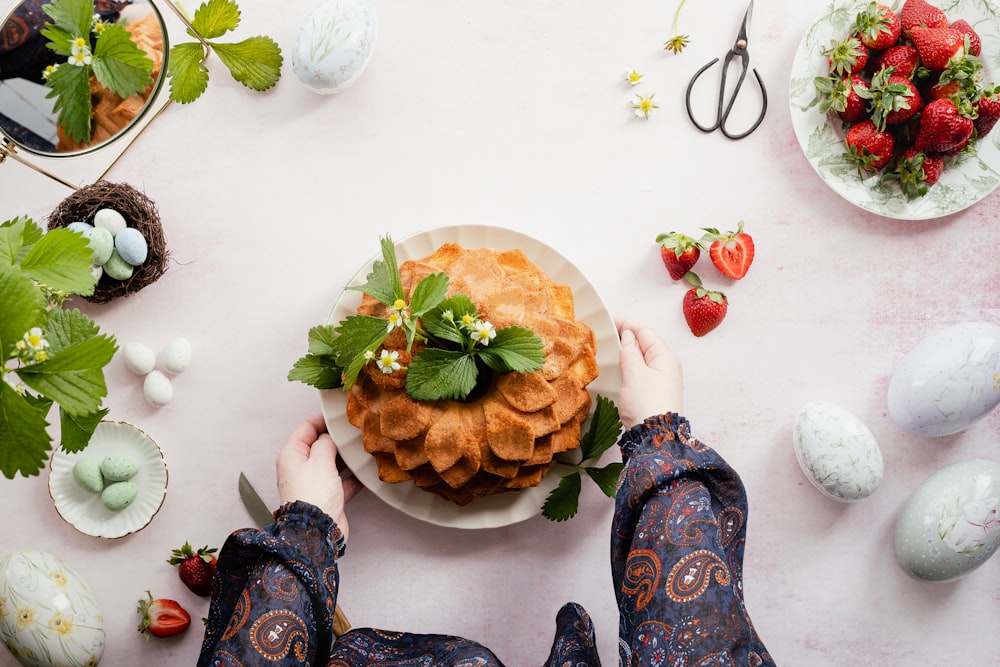 a person holding a plate of food on a table