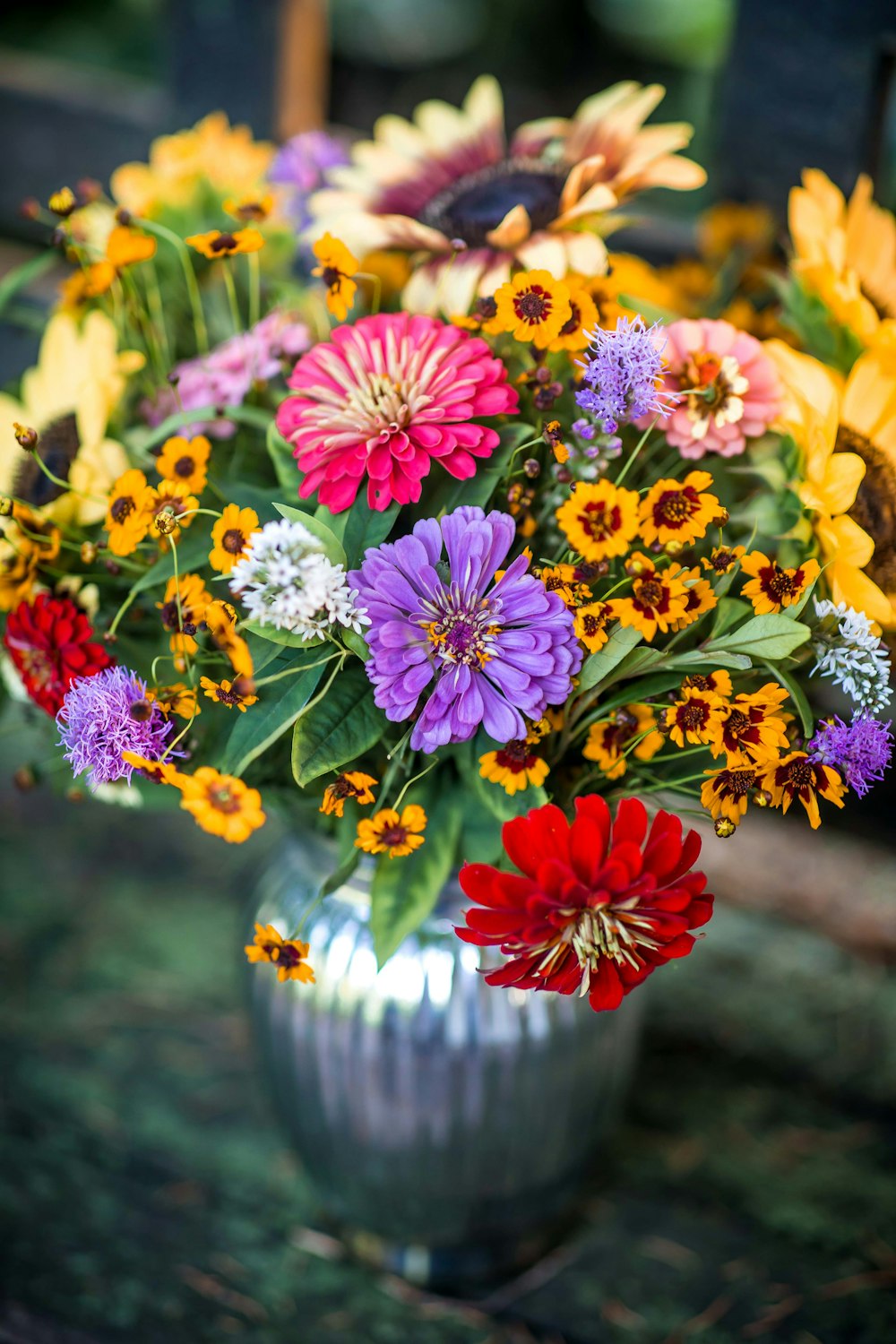 a vase filled with lots of different colored flowers