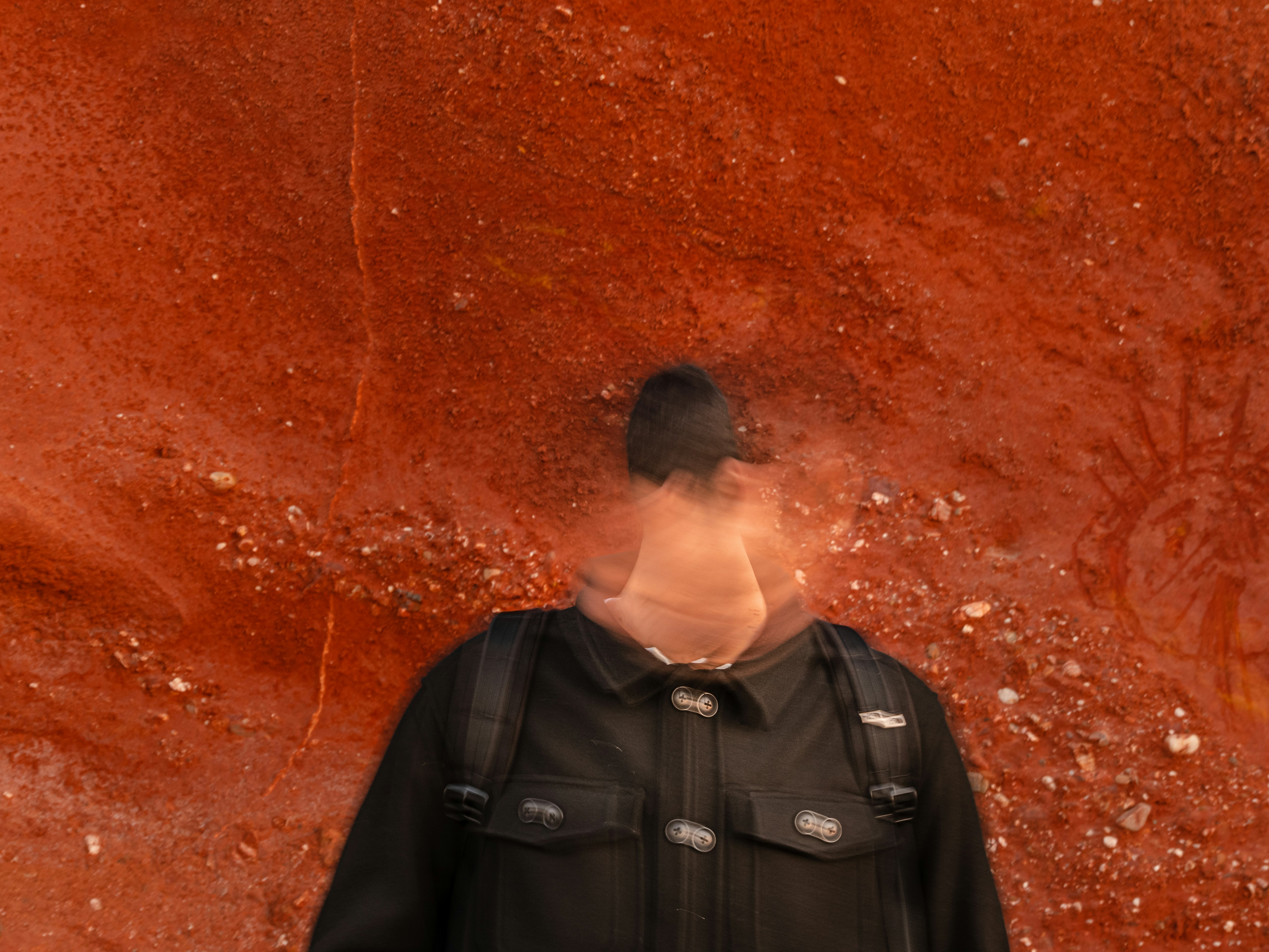 a person standing in front of a red wall