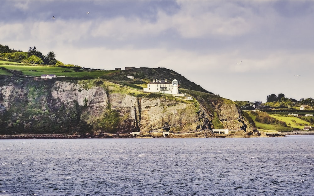 a house on a cliff overlooking a body of water