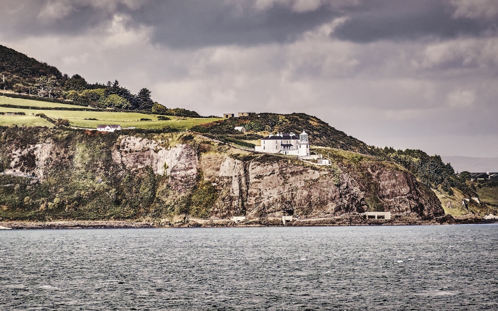 a house on a cliff overlooking a body of water