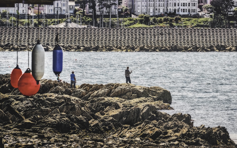 a group of people standing on top of a rocky shore