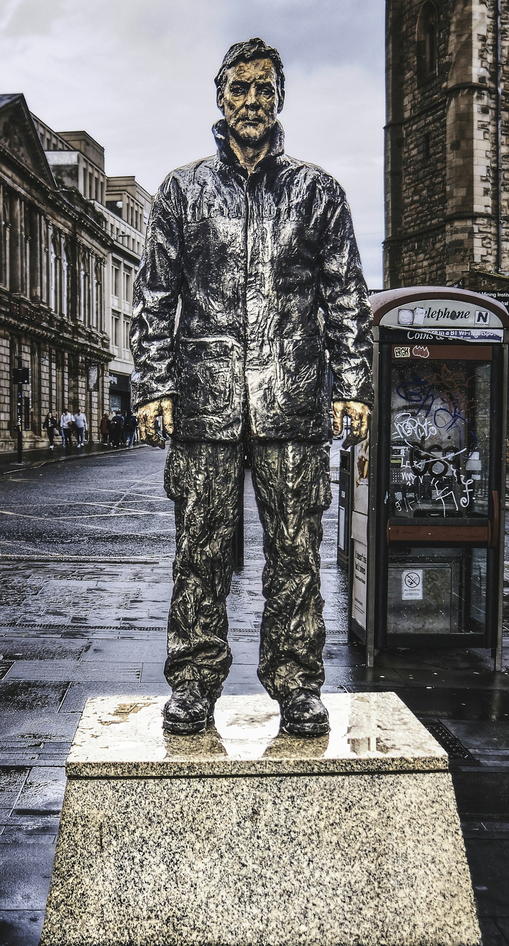 a statue of a man standing on a sidewalk