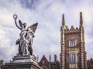 a statue of an angel stands in front of a building