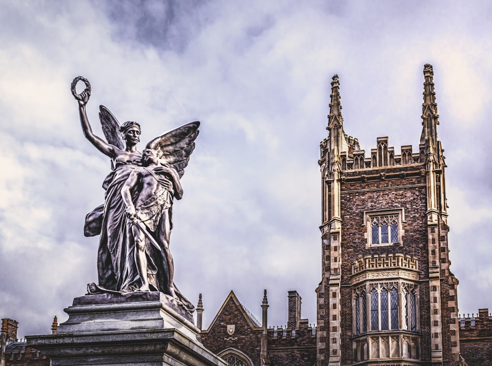 a statue of an angel stands in front of a building