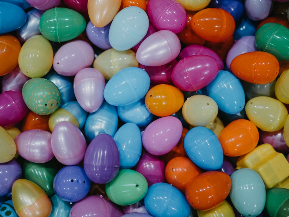 a bunch of colorful eggs are in a pile
