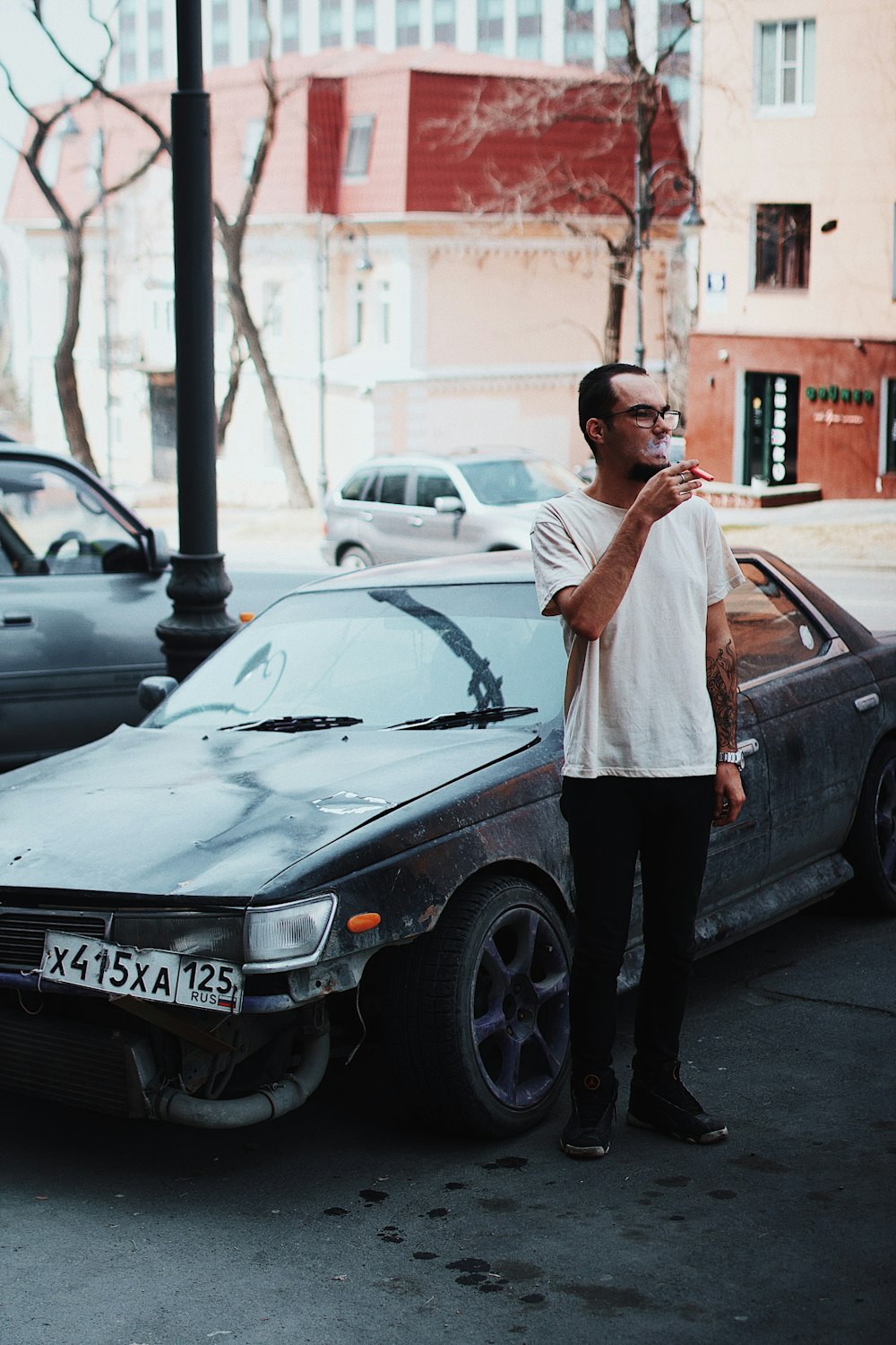 a man standing next to a wrecked car