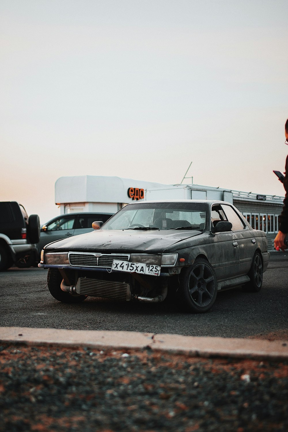 a car parked in a parking lot next to a woman