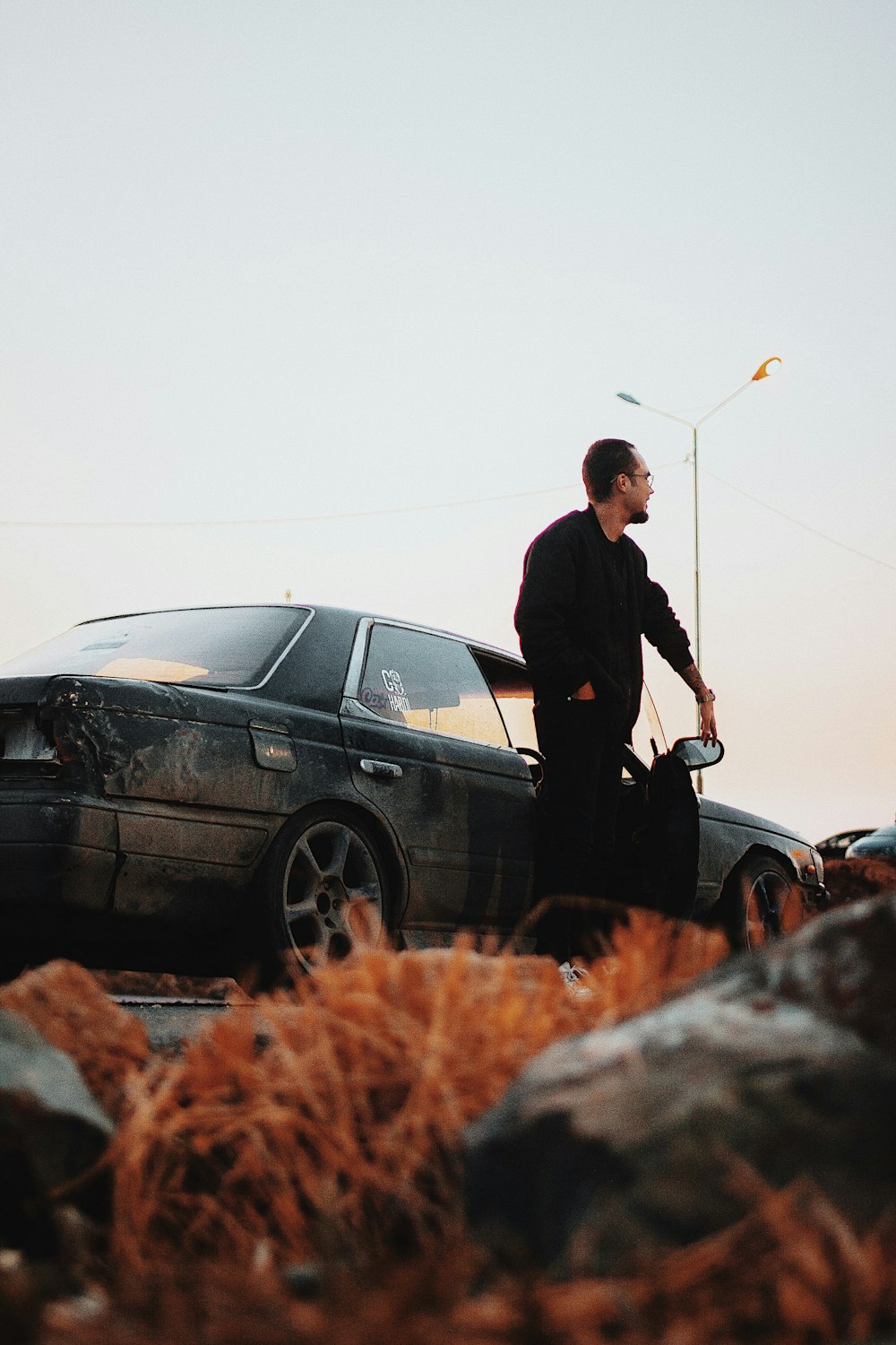 a man standing next to a black car