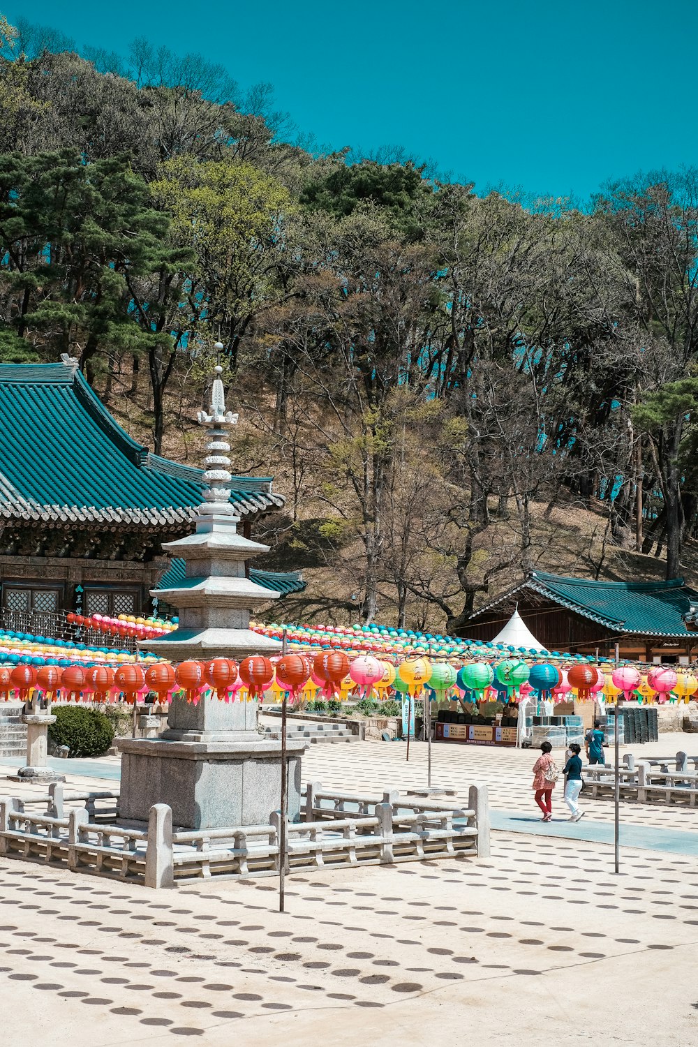 a group of people walking around a park with umbrellas