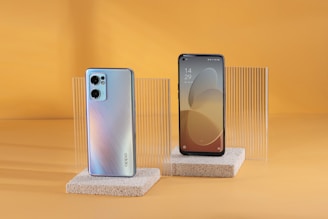 two new cell phones are displayed on a stand