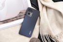 a cell phone sitting on top of a table next to a book