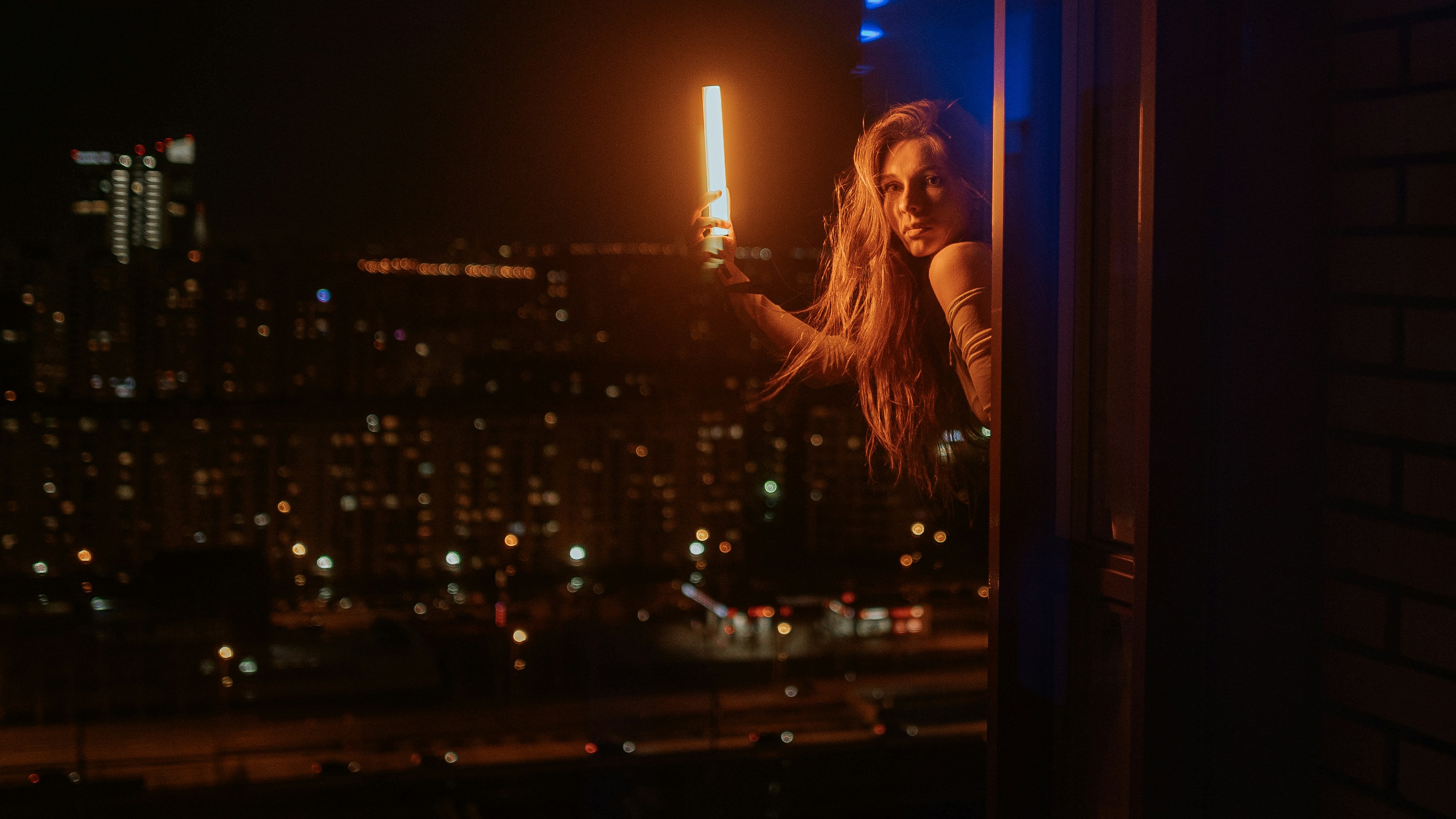 a woman standing on a window sill at night