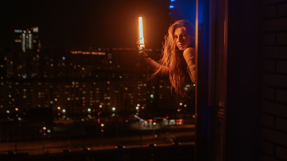 a woman standing on a window sill at night