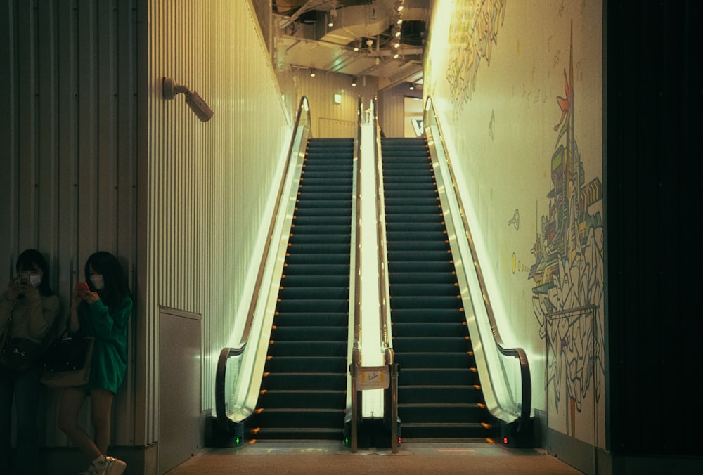 a woman standing at the bottom of an escalator