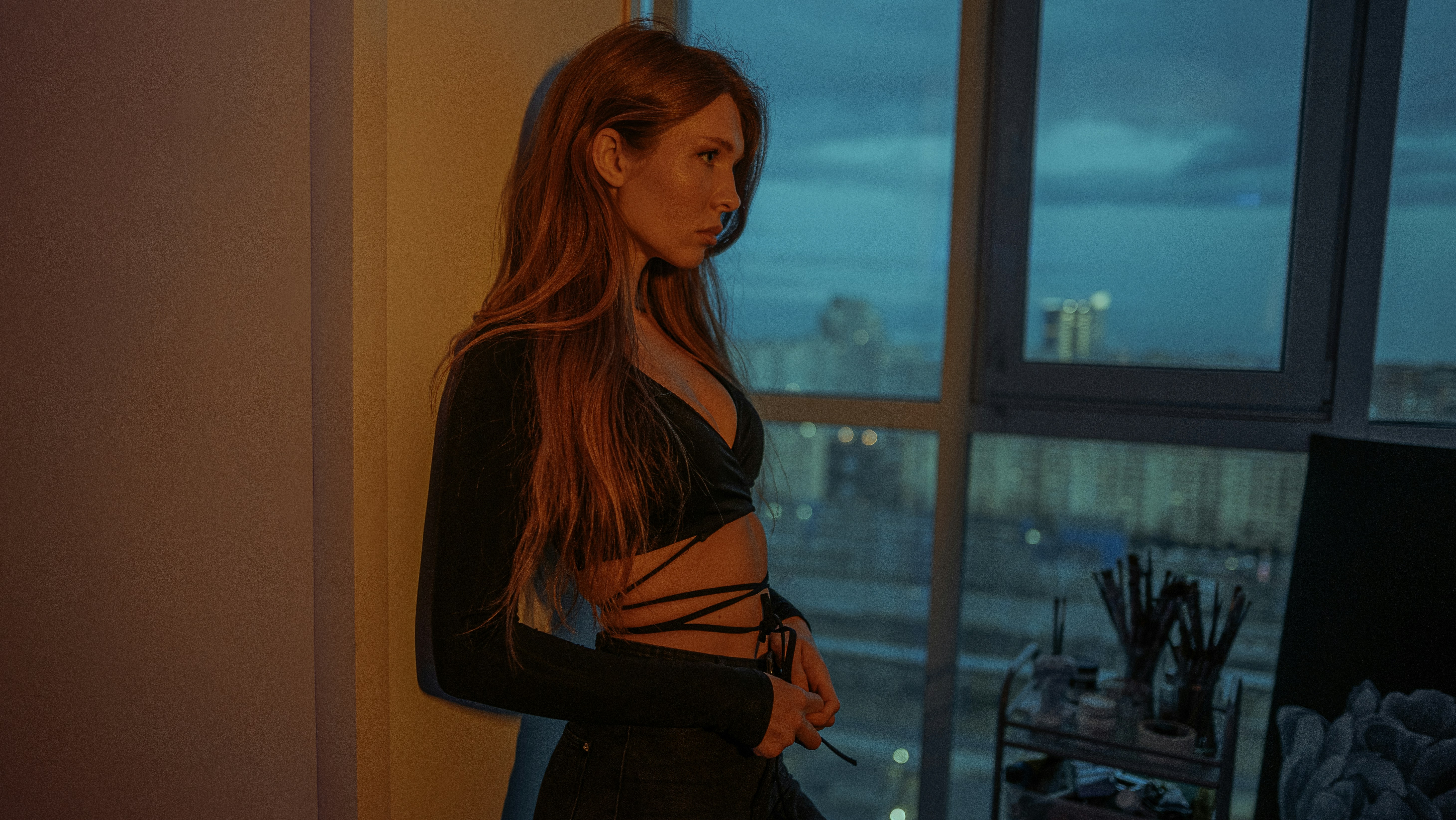 a woman standing in front of a window in a room