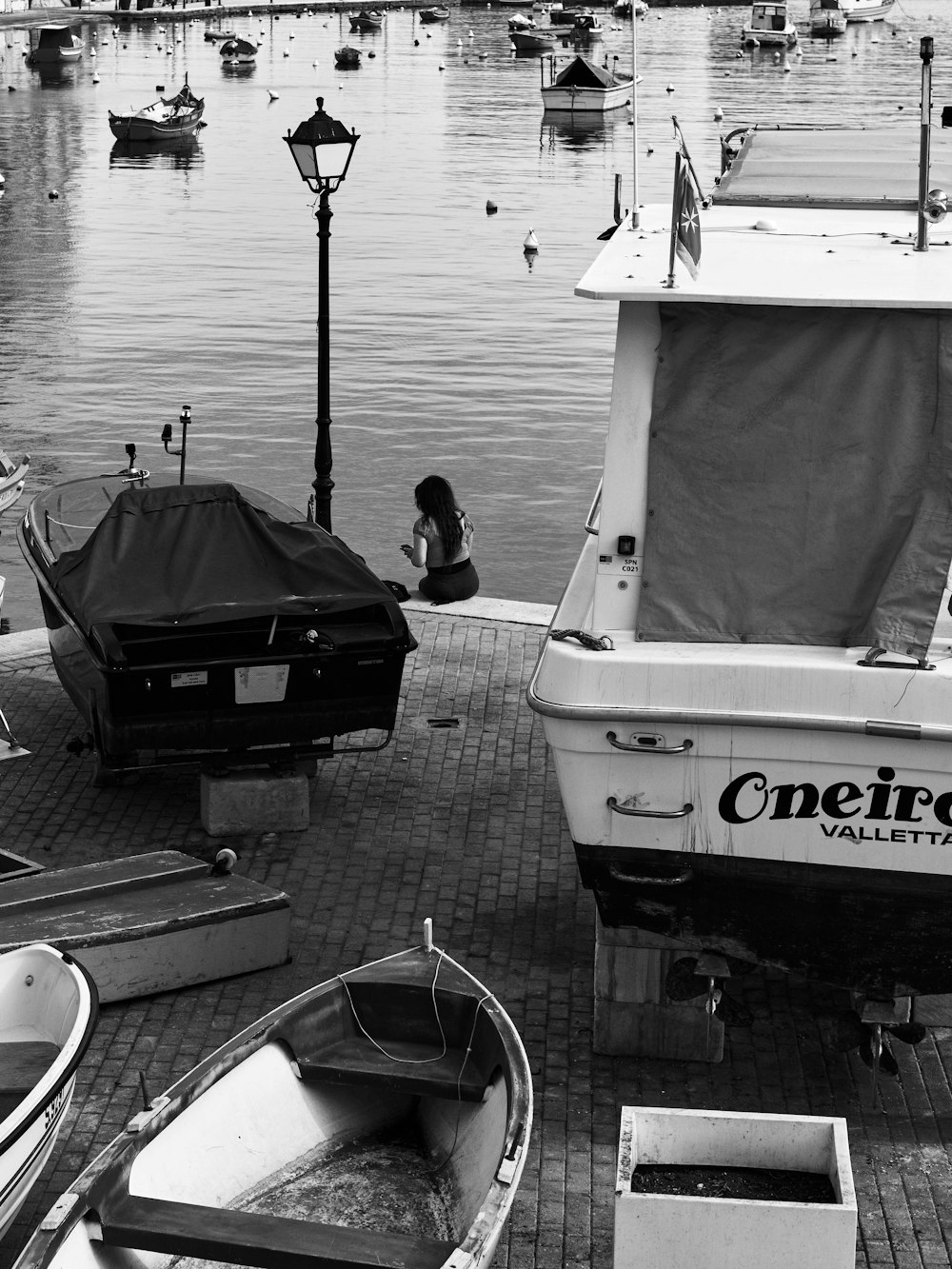 a black and white photo of boats docked at a pier