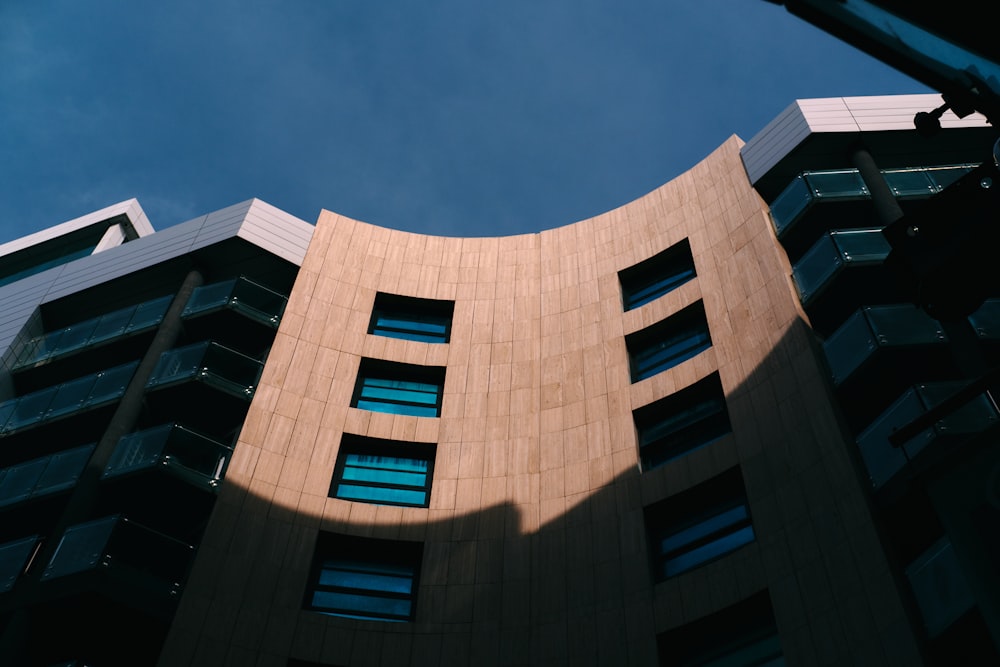 a tall building with windows and a sky background