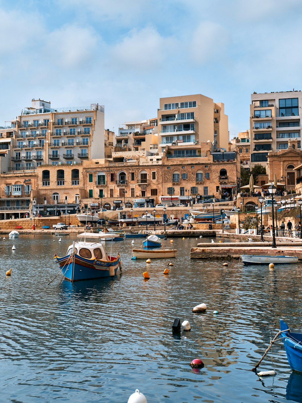 a harbor filled with lots of boats next to tall buildings