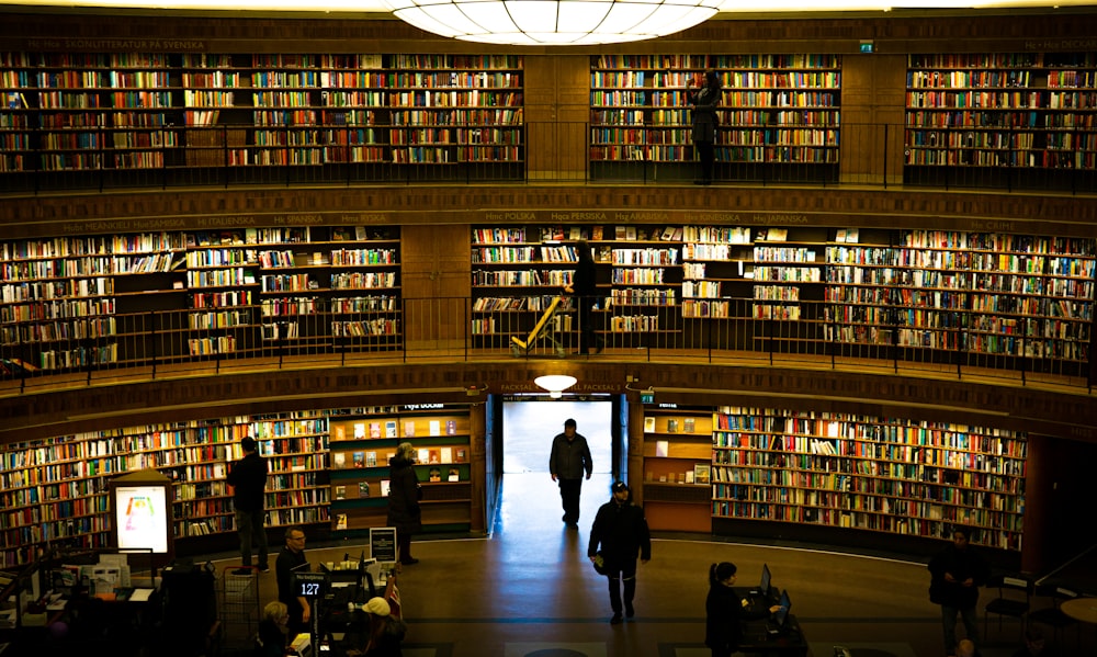 a man walking into a library filled with lots of books