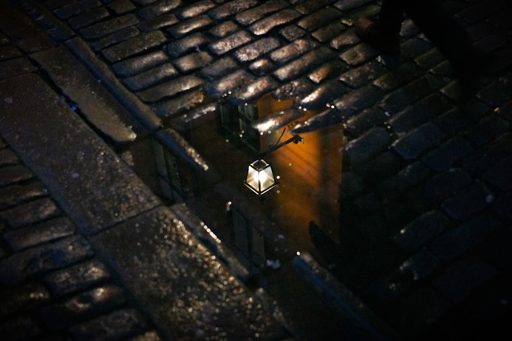 a street light on a cobblestone road at night