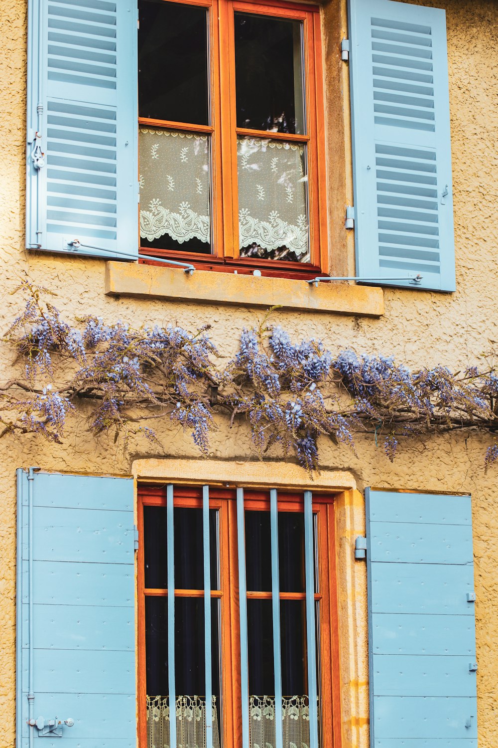 a yellow building with blue shutters and windows