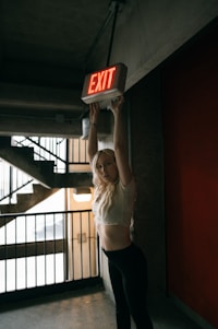 a woman holding a sign that says exit