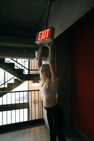 a woman holding a sign that says exit